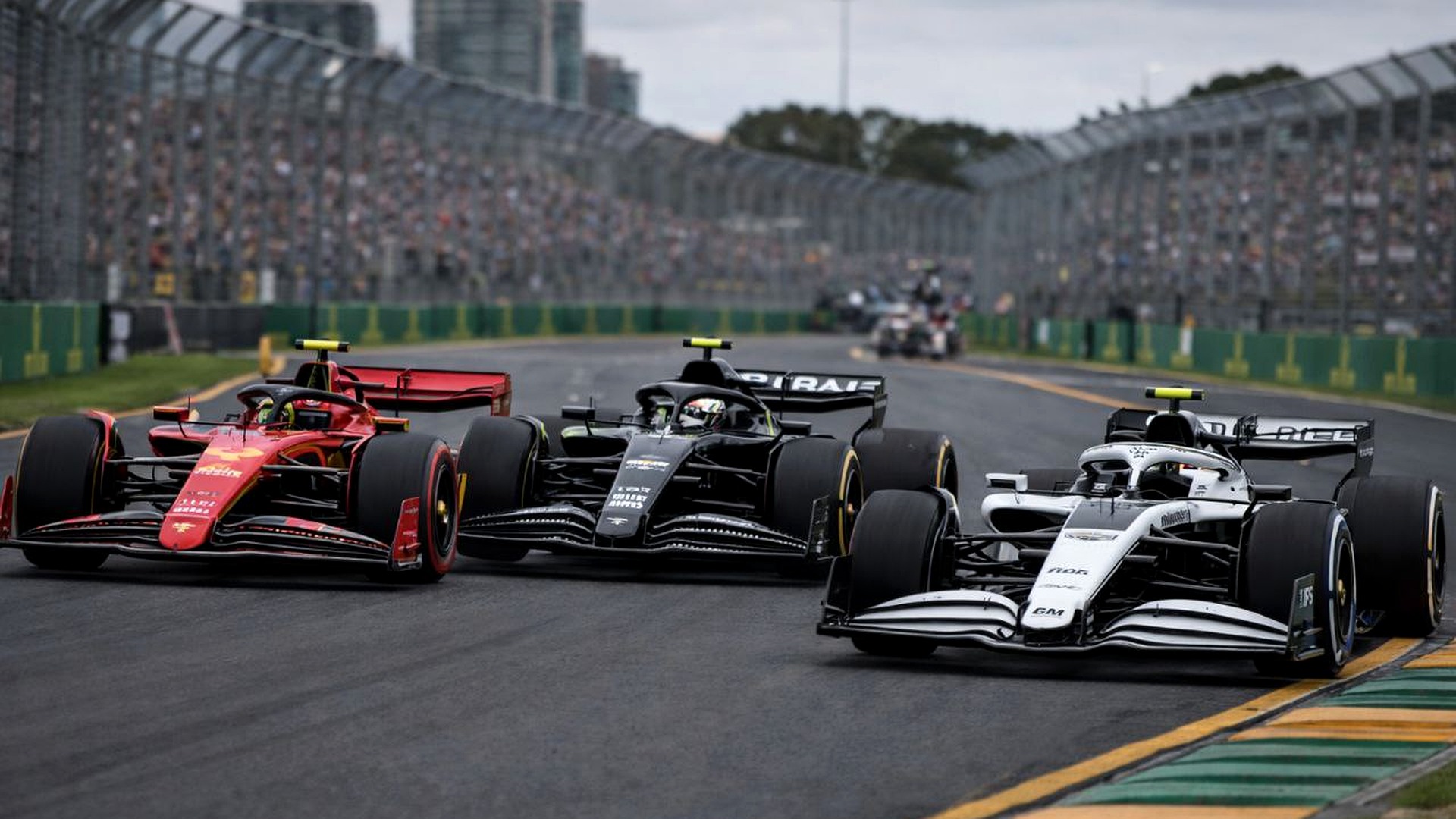 Three Formula 1 cars side by side at Albert Park during race weekend